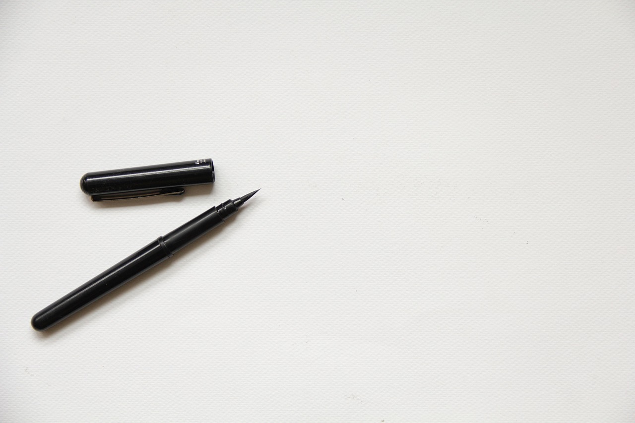 Brush pen resting on textured white paper