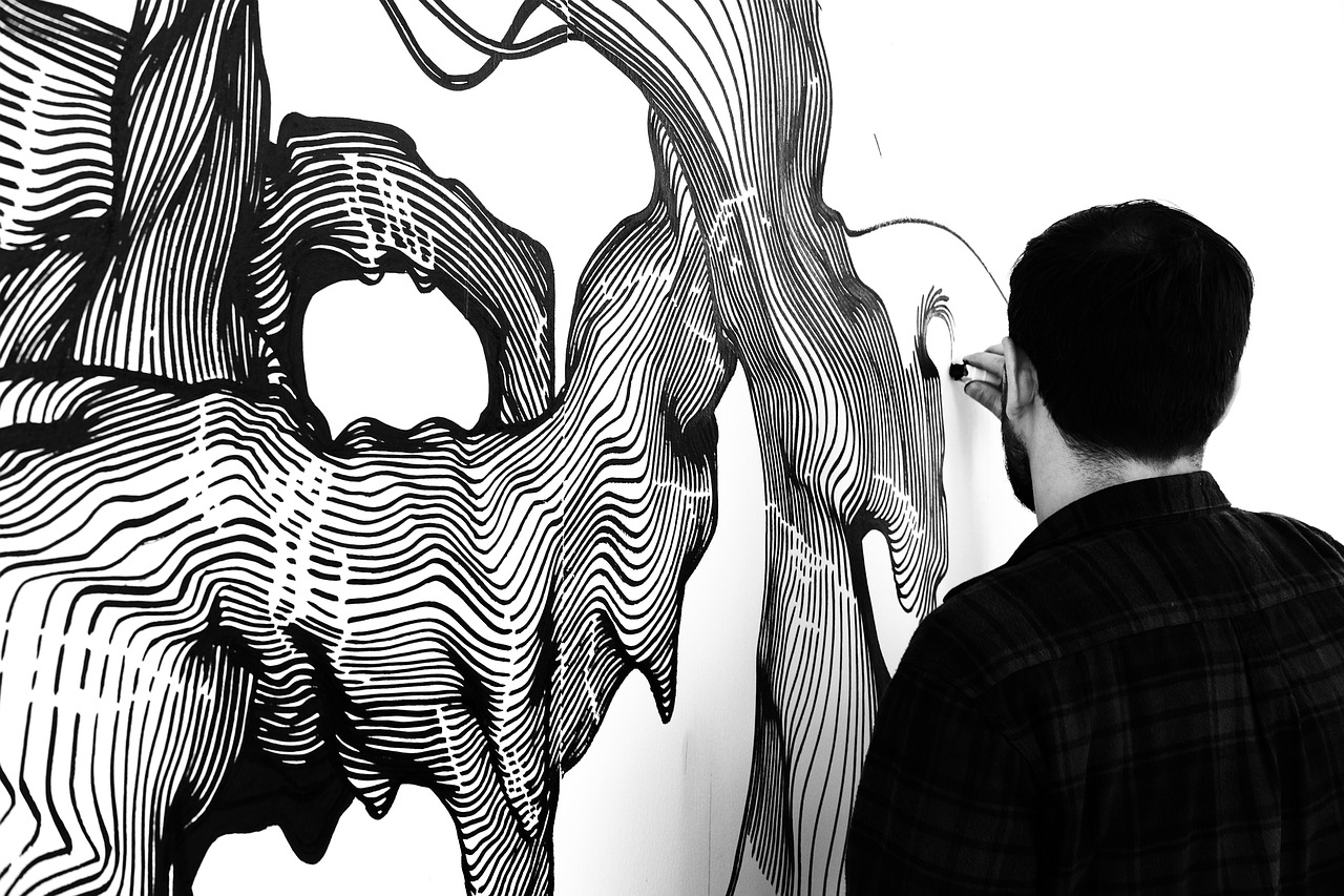 Sweeping black line work drawn across a white wall